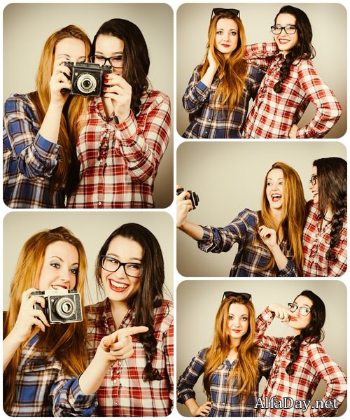Funny hipster girls taking pictures with an old camera - Stock Photo