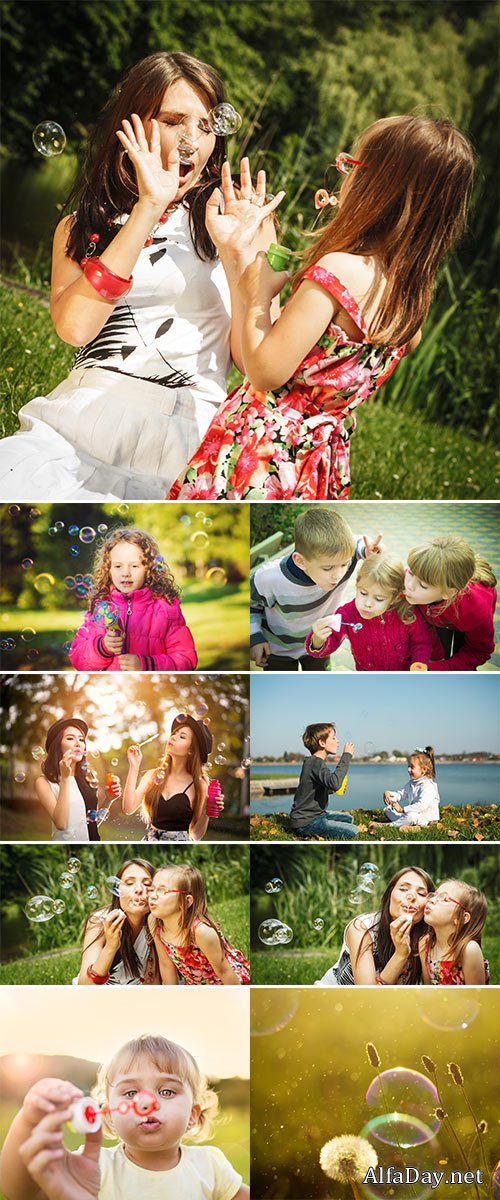 Stock Photo Little girl having fun blowing soap bubbles in park green blurred background
