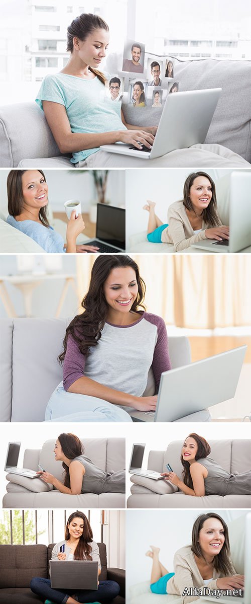 Stock Photo Happy woman sitting on couch using her laptop at home in the living room